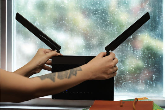 a woman positioning a 5G router infront of a window with angled antennas